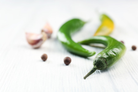 Green chili peppers, garlic on light wooden backgroundの写真素材