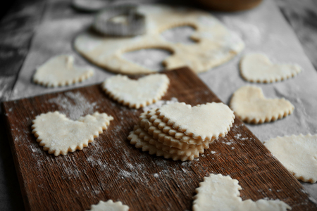 Uncooked heart shaped biscuits on a table