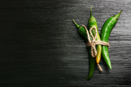 Green chili peppers on dark wooden backgroundの写真素材