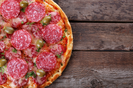 Delicious tasty pizza on wooden backgroundの写真素材