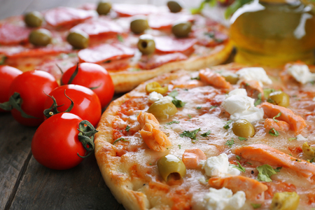 Delicious tasty pizzas with ingredients on table, closeupの写真素材