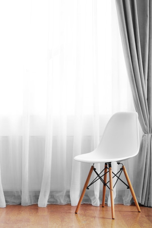 Chair in the room near the window with curtainsの写真素材