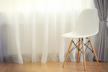 Chair in the room near the window with curtainsの写真素材