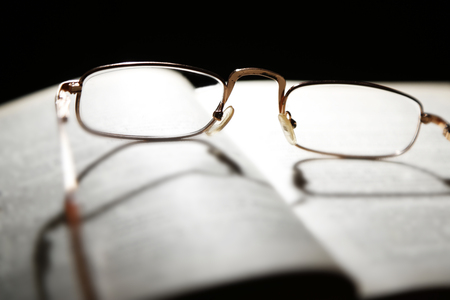 Opened book and eyeglasses on it, close upの写真素材