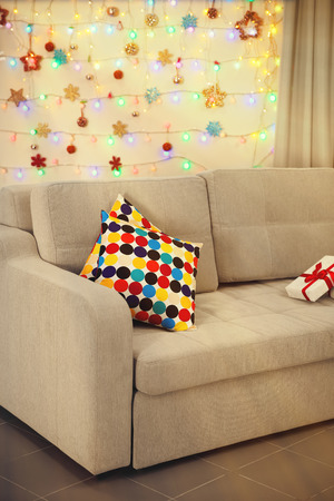 Light grey couch with pillows on Christmas lights backgroundの写真素材