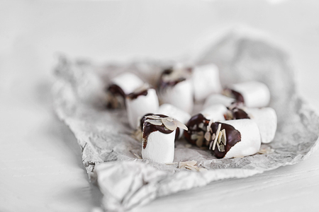 Tasty marshmallows with chocolate on paper, close upの写真素材
