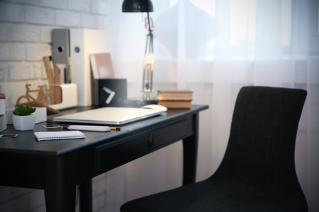 Workplace with laptop on table at homeの写真素材
