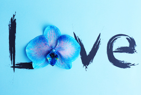 Inscription love with orchid on blue backgroundの写真素材