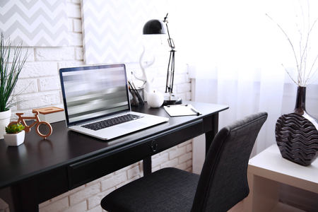 Workplace with laptop on table at homeの写真素材