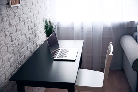 Workplace a home with laptop and table on window backgroundの写真素材