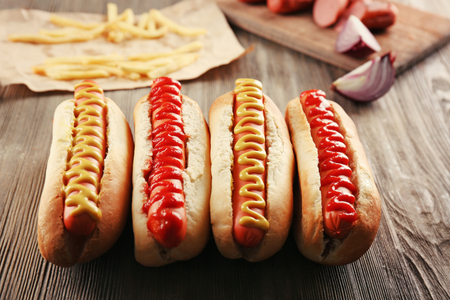Hot dogs with fried potatoes and sausages on wooden backgroundの写真素材