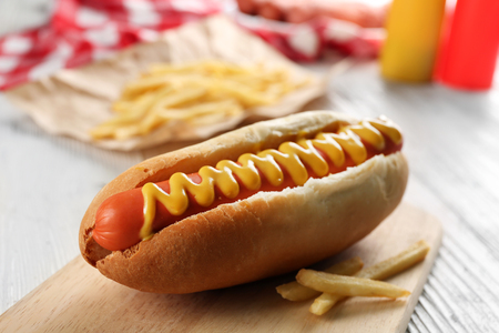 Hot dog with fried potatoes on craft paperの写真素材