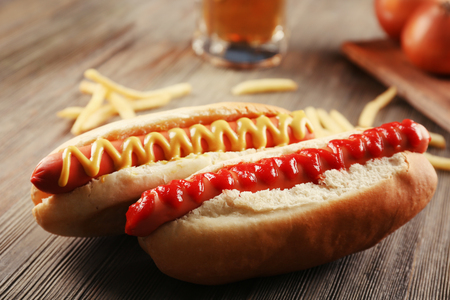 Hot dogs with fried potatoes and onions on wooden backgroundの写真素材