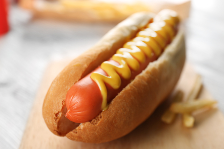 Hot dog with fried potatoes on craft paperの写真素材