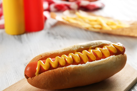 Hot dog with fried potatoes on craft paperの写真素材