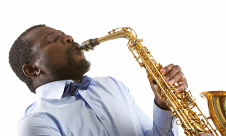 African American jazz musician playing the saxophone, isolated on whiteの写真素材