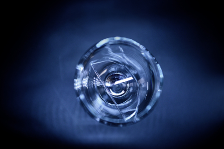 Broken wine glass on dark blue backgroundの写真素材