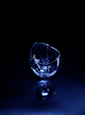 Broken wine glass on dark blue backgroundの写真素材