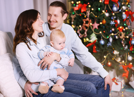 Happy family on sofa in the decorated Christmas roomの写真素材