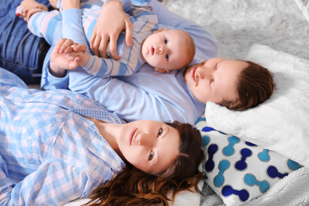 Happy family laying on the floor in the decorated Christmas roomの写真素材