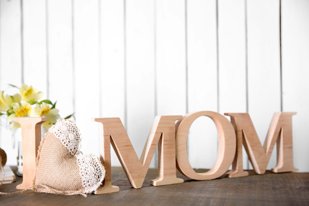 I love mom inscription of wooden letters with heart on white wall backgroundの写真素材