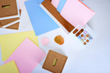 Coloured papers, pens and stickers on white tableの写真素材
