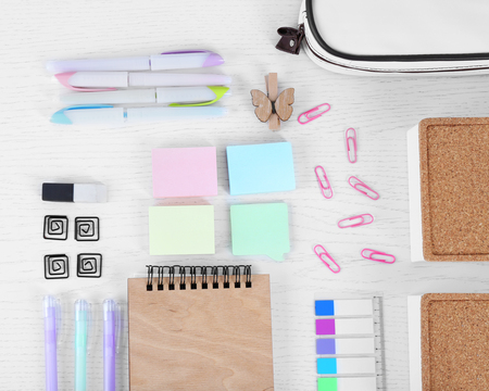 Notebook with stationery and pencil case on a white tableの写真素材