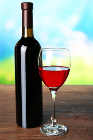Wine in glass and in bottle on blurred natural backgroundの写真素材