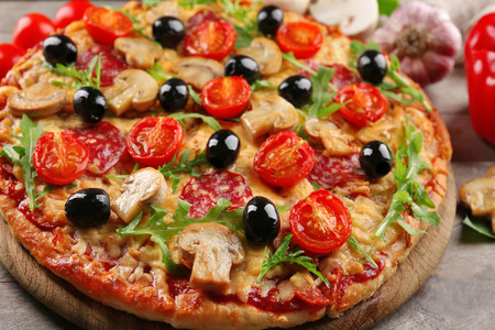 Delicious tasty pizza with ingredients on wooden tableの写真素材
