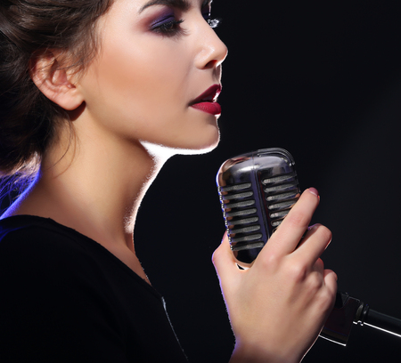 Portrait of beautiful singing woman on dark backgroundの写真素材