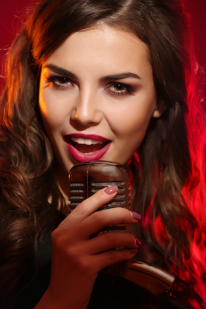 Attractive female singer on red background, close upの写真素材