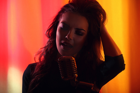 Silhouette of singing woman on colourful background, close upの写真素材