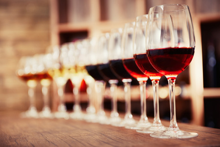 Many glasses of different wine in a row on bar counterの写真素材