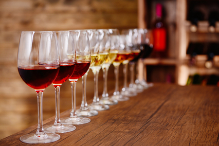 Many glasses of different wine in a row on bar counterの写真素材