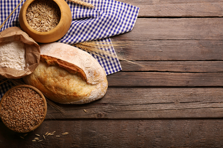 Fresh baked bread, flour, wheat and napkin on the wooden backgroundの写真素材