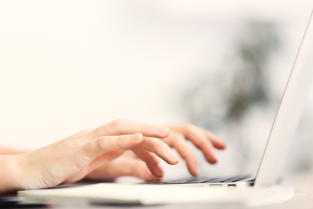 Woman sitting at the table and working with laptopの写真素材