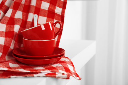 Red cups, saucers and napkin on a white background, close upの写真素材