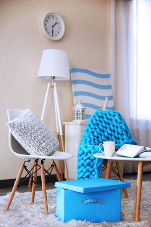 Room design with white furniture, picture, clock and floor lamp over beige wallの写真素材
