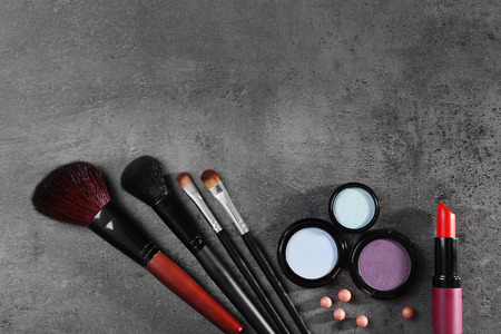 Makeup brushes and cosmetics on gray backgroundの写真素材