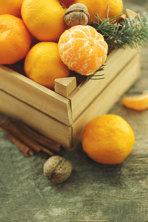 Tangerines in wooden crate, on old wooden table, close upの写真素材