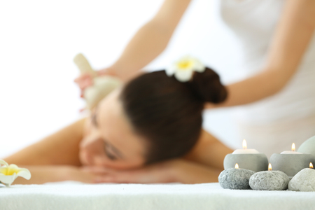 One do relaxing massage with herbal balls to pretty woman, close upの写真素材