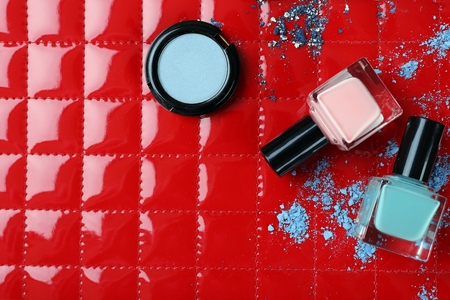 Blue shadows and crushed nail polish on red backgroundの写真素材