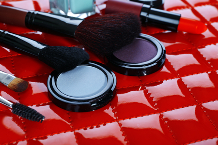 Cosmetics and makeup brushes on red backgroundの写真素材