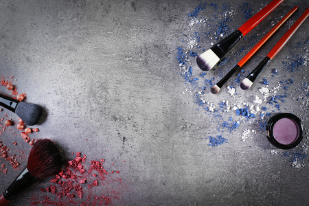 Makeup brushes with shadows and pink rouges on gray background closeupの写真素材