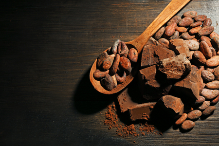 Spoon with aromatic cocoa and chocolate on wooden background, close upの写真素材