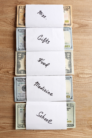 Rolls of money for needs on wooden backgroundの写真素材