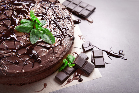 Decorated chocolate pie with mint and chocolate bar on grey tableの写真素材