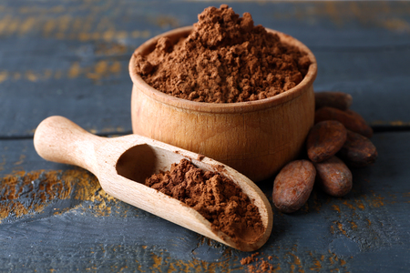 Bowl with aromatic cocoa powder on scratched wooden background, close upの写真素材