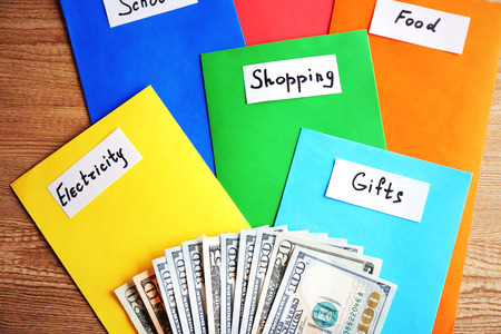Colourful envelopes with money for needs on wooden backgroundの写真素材