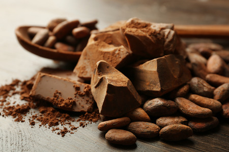 Spoon with aromatic cocoa and chocolate on wooden background, close upの写真素材
